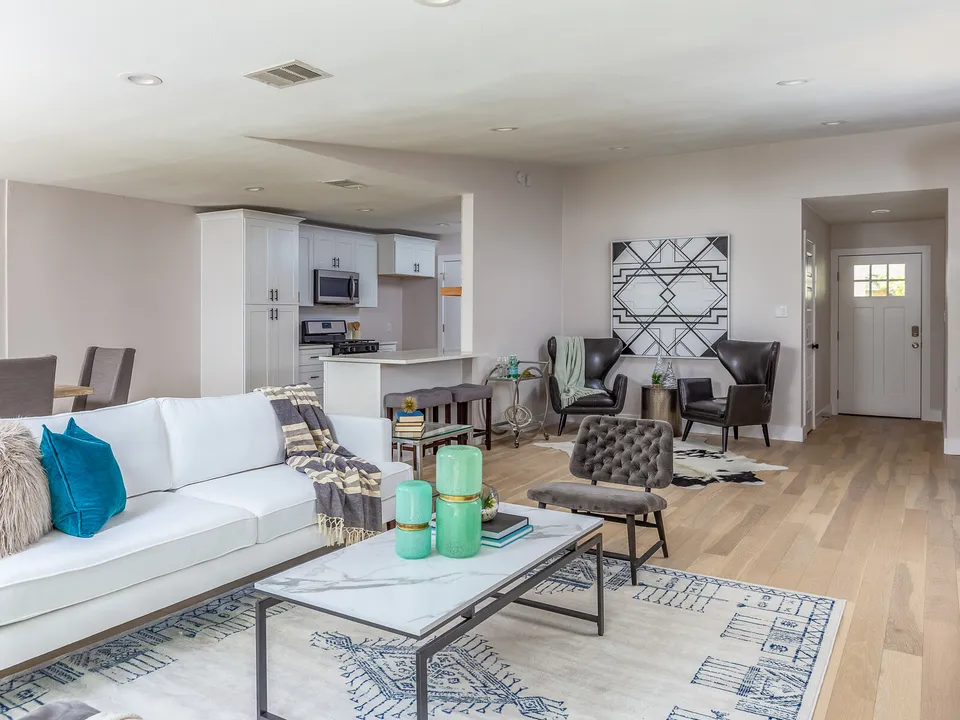 Open living room with the kitchen and front door beyond