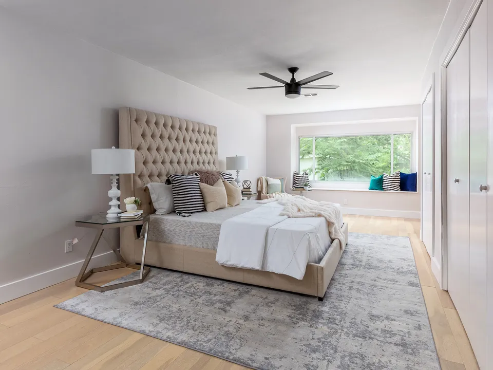 Primary bedroom with a tufted headboard and a window seat