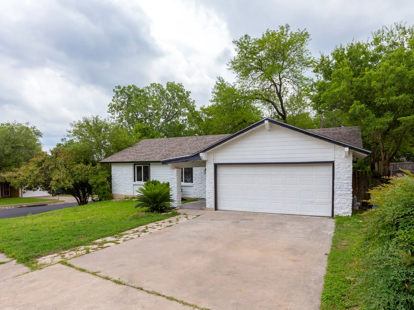 White painted brick house with a two-car garage and driveway
