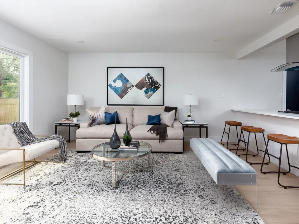 Living room with a cream sectional, open to a breakfast bar