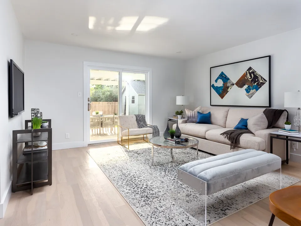 Living room with a cream sectional and sliding doors to the backyard