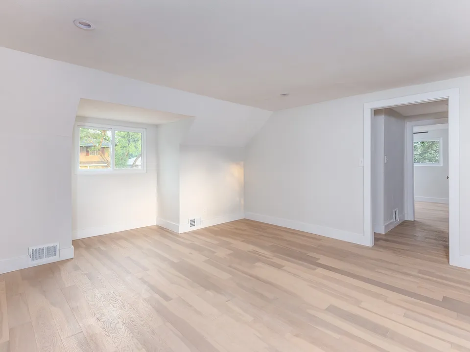 Upstairs room with a sloped ceiling and a dormer window