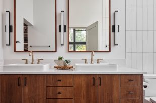 a bathroom with double sinks and a toilet