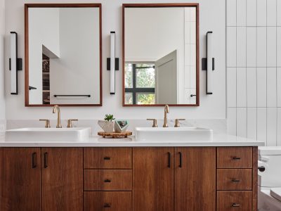 a bathroom with double sinks and a toilet